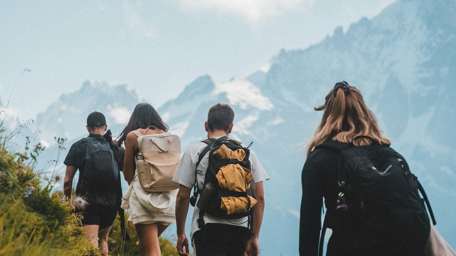 A group of young people hiking up a rocky mountain path